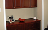Dual file cabinets and upper cabinets - Recess area and lighting designed and built to accommodate furniture - Mahogany color - Premier Finish.